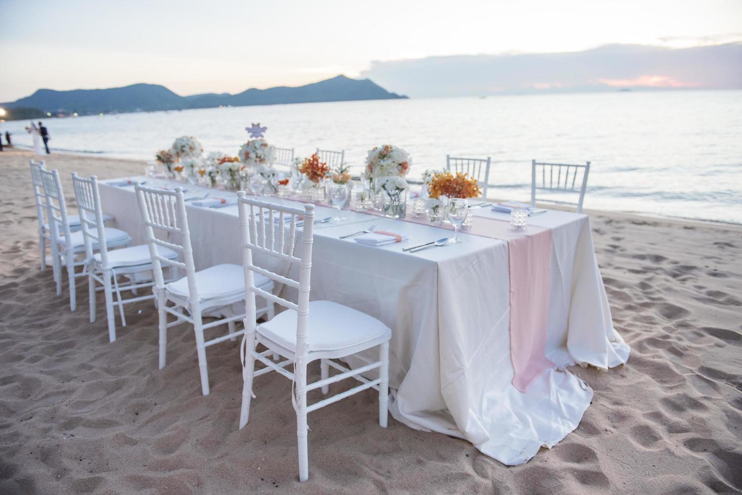 det eleganta middagsbordet på stranden foto