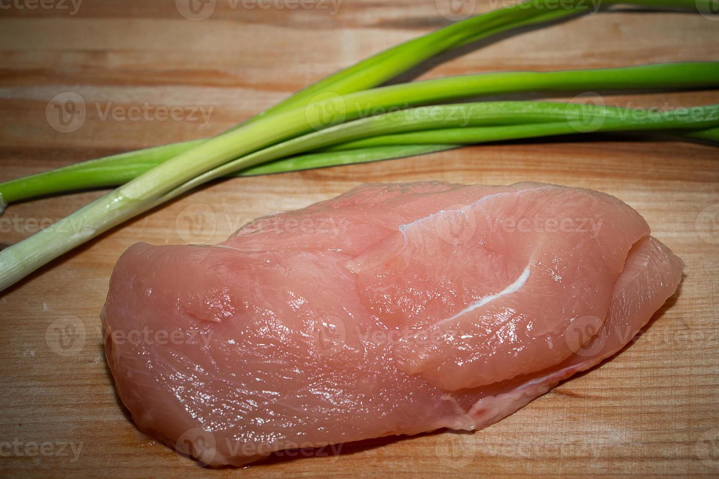kycklingfilé med grönsaker på en skärbräda foto