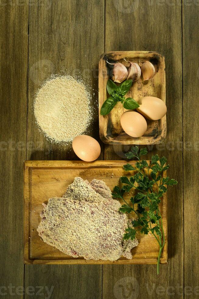 kalvkött milanese presenteras på de tabell med Ingredienser foto