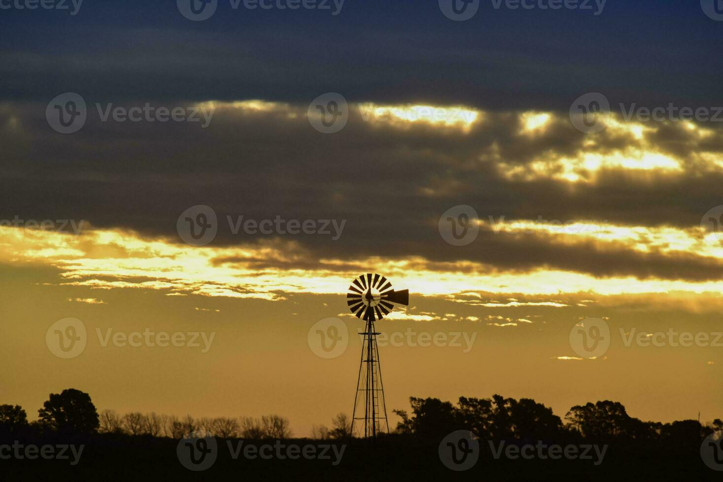 landskap med väderkvarn på solnedgång, pampas, patagonien, argentina foto