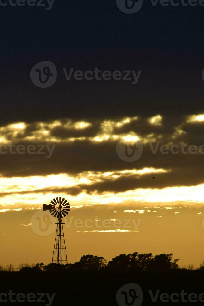 landskap med väderkvarn på solnedgång, pampas, patagonien, argentina foto