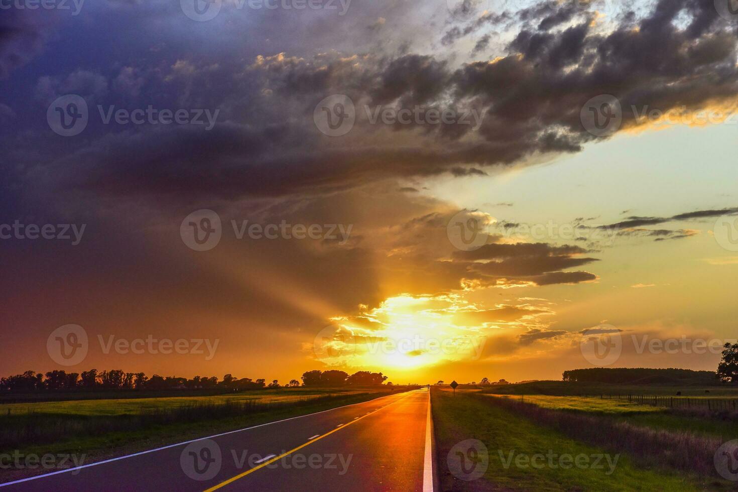 landskap med väg och stormig himmel på solnedgång foto