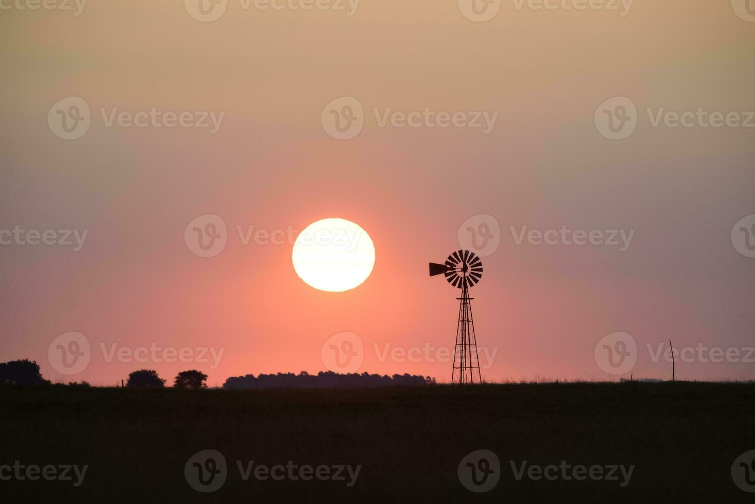 väderkvarn i landsbygden på solnedgång, pampas, patagonien, argentina. foto