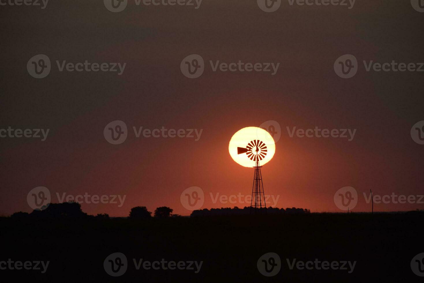 väderkvarn i landsbygden på solnedgång, pampas, patagonien, argentina. foto