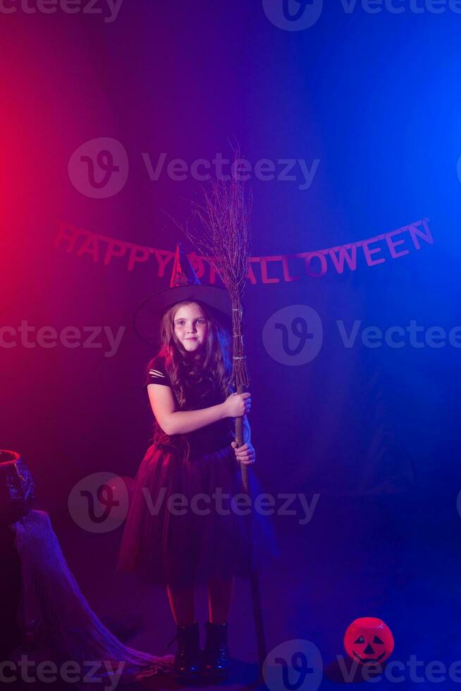 rolig barn flicka i häxa kostym för halloween med pumpa jack. foto