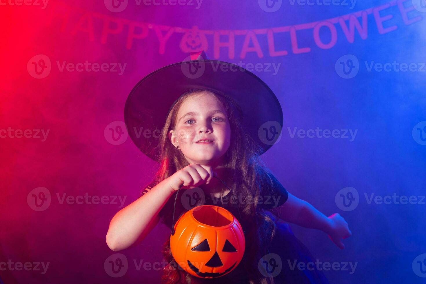 rolig barn flicka i häxa kostym för halloween med pumpa jack. foto