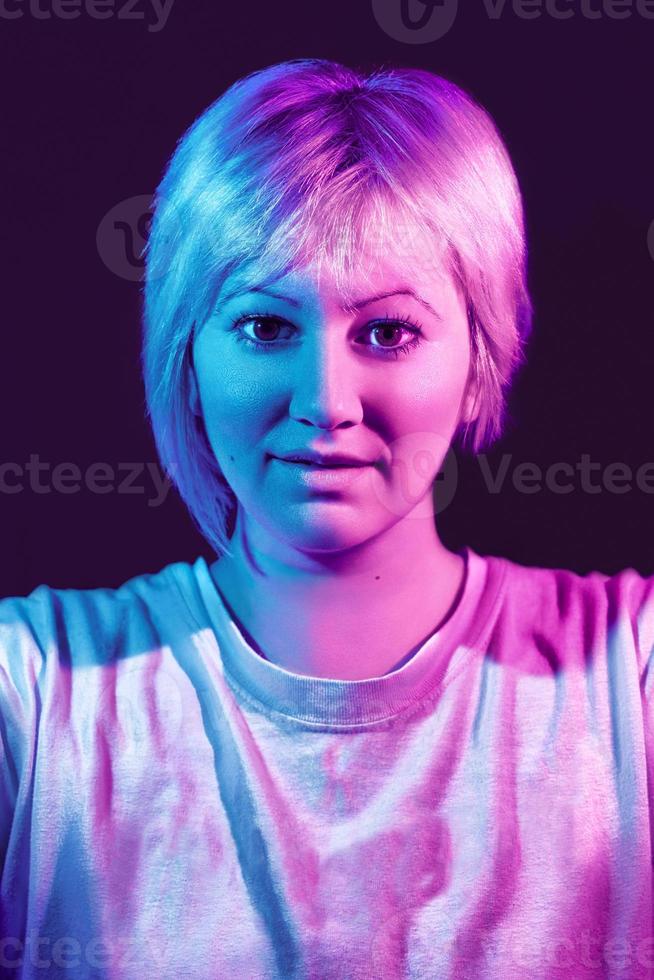 porträtt av ung kvinnlig kvinna med en vit t-shirt och neonljus. foto