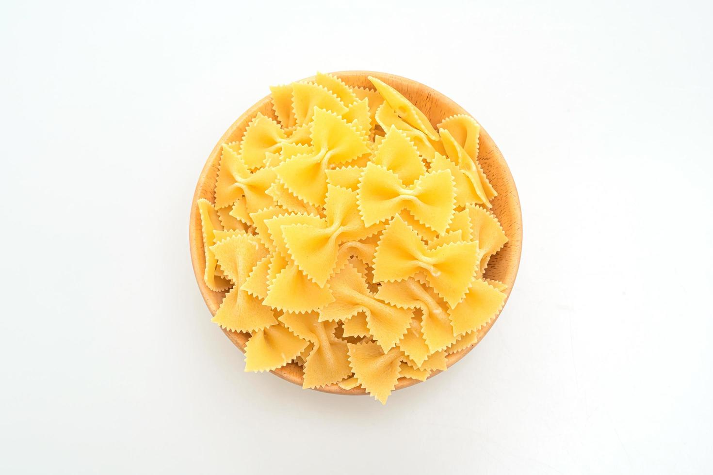 torr okokt farfalle pasta på vit bakgrund foto