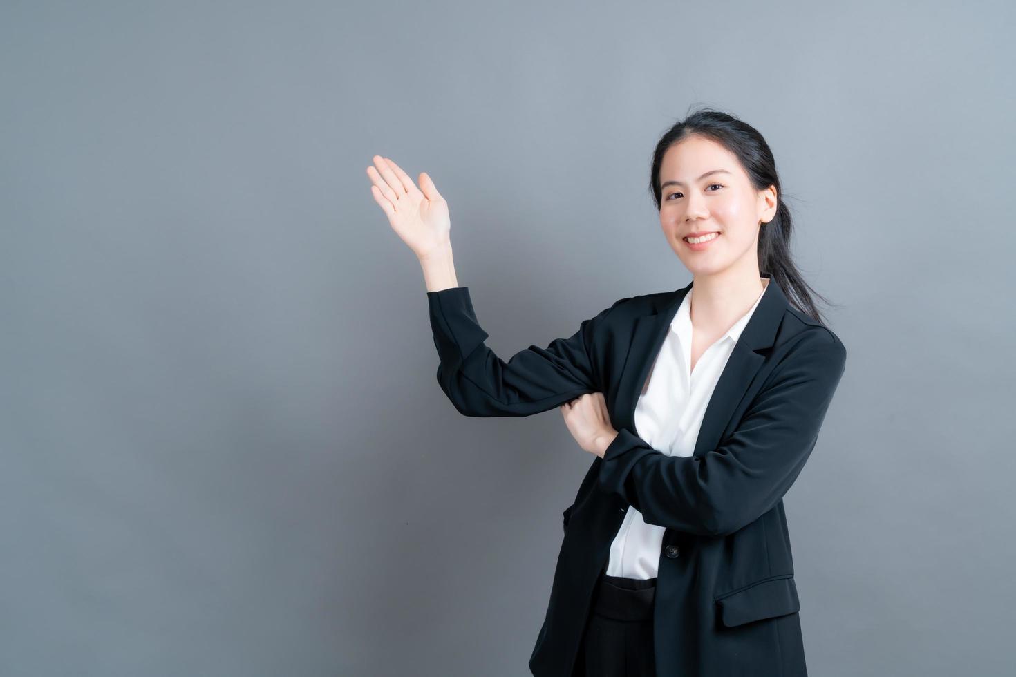 asiatisk kvinna med handen som presenterar på sidan foto