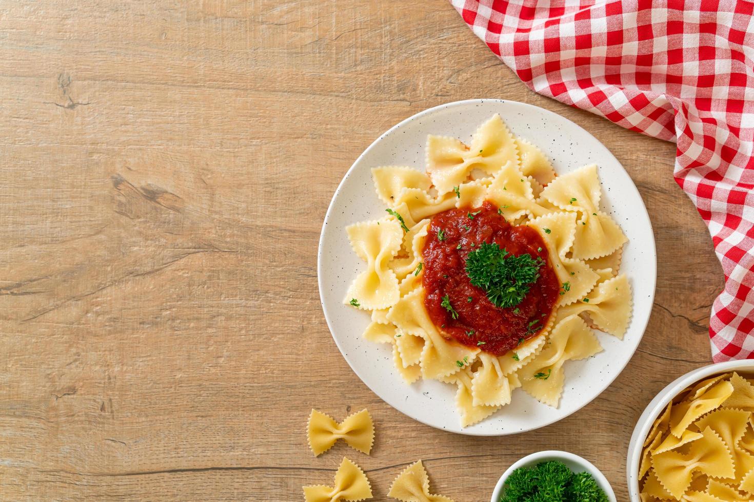 farfalle pasta i tomatsås med persilja - italiensk matstil foto