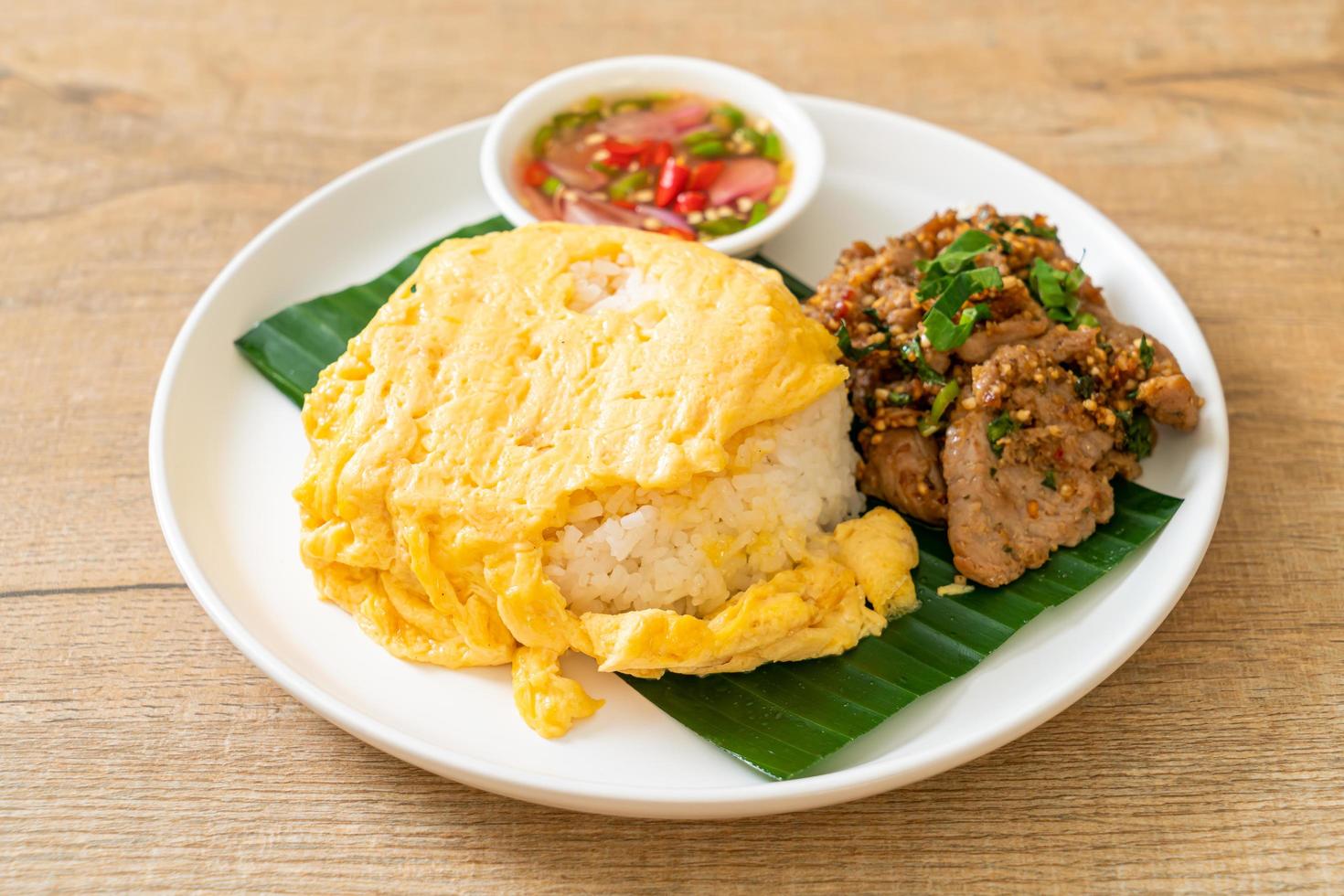 ägg på toppat ris med grillat fläsk och kryddig sås - asiatisk matstil foto