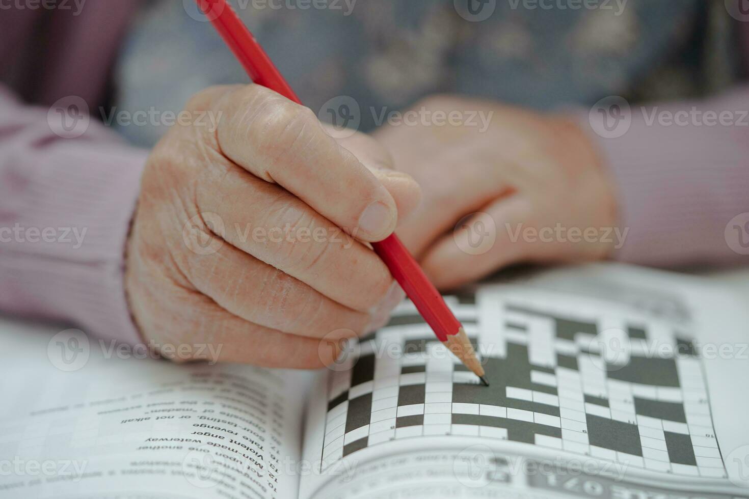 asiatisk äldre kvinna spelar sudoku pussel spel till öva hjärna Träning för demens förebyggande, alzheimers sjukdom. foto