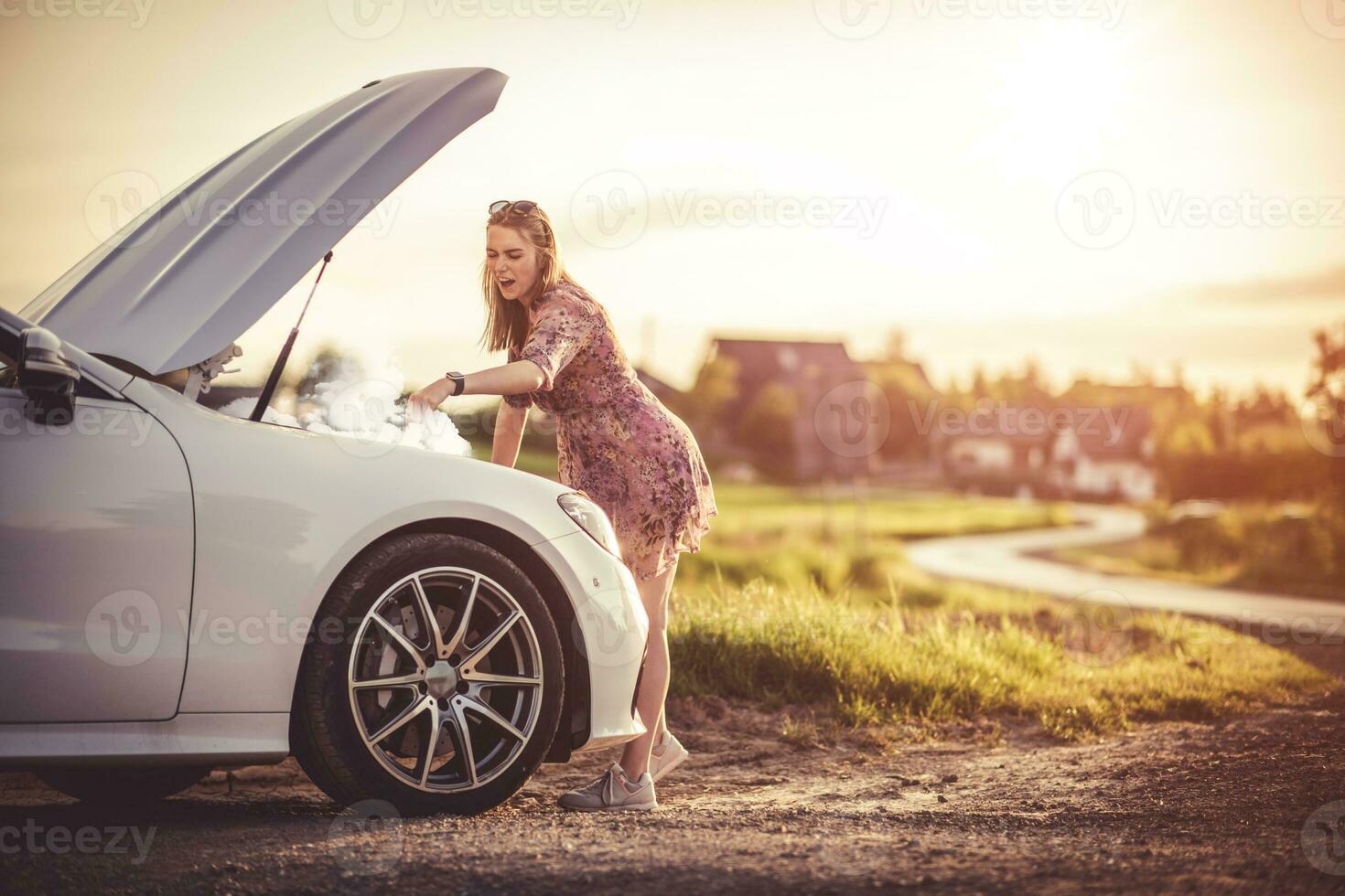 kvinna förbi de öppen huva av en bruten bil. foto