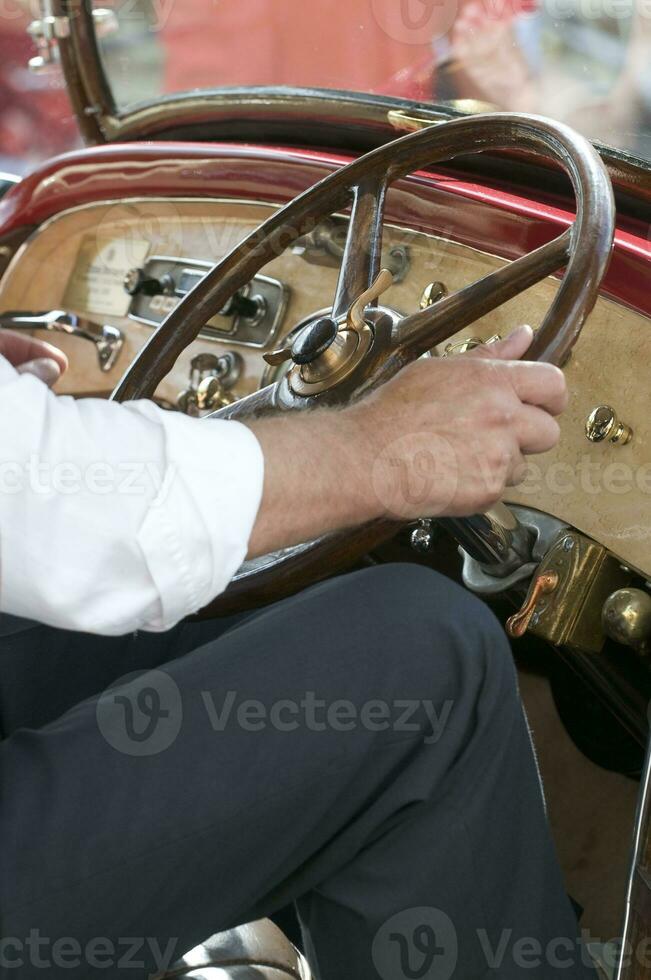 gammal bil - närbild av förarens händer på styrning hjul foto