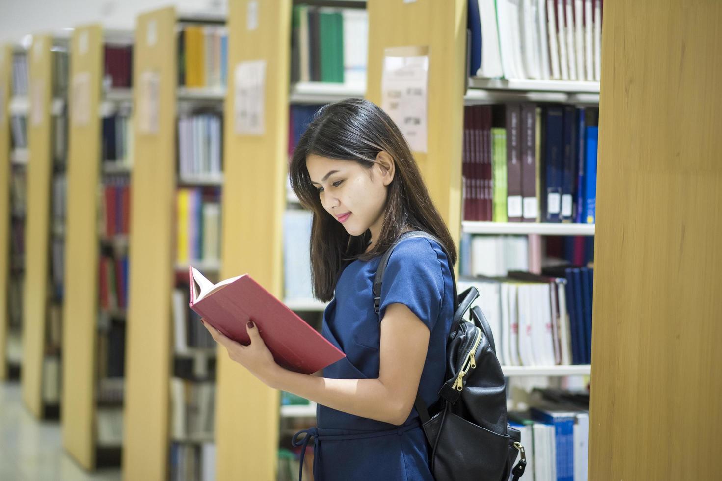 vackra kvinnliga asiatiska universitetsstudenter i biblioteket foto