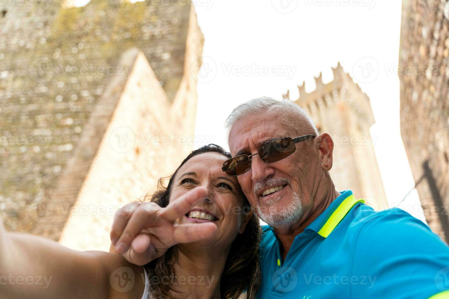 skön mitten åldrig par tar en selfie i de gator av en trevlig italiensk by foto