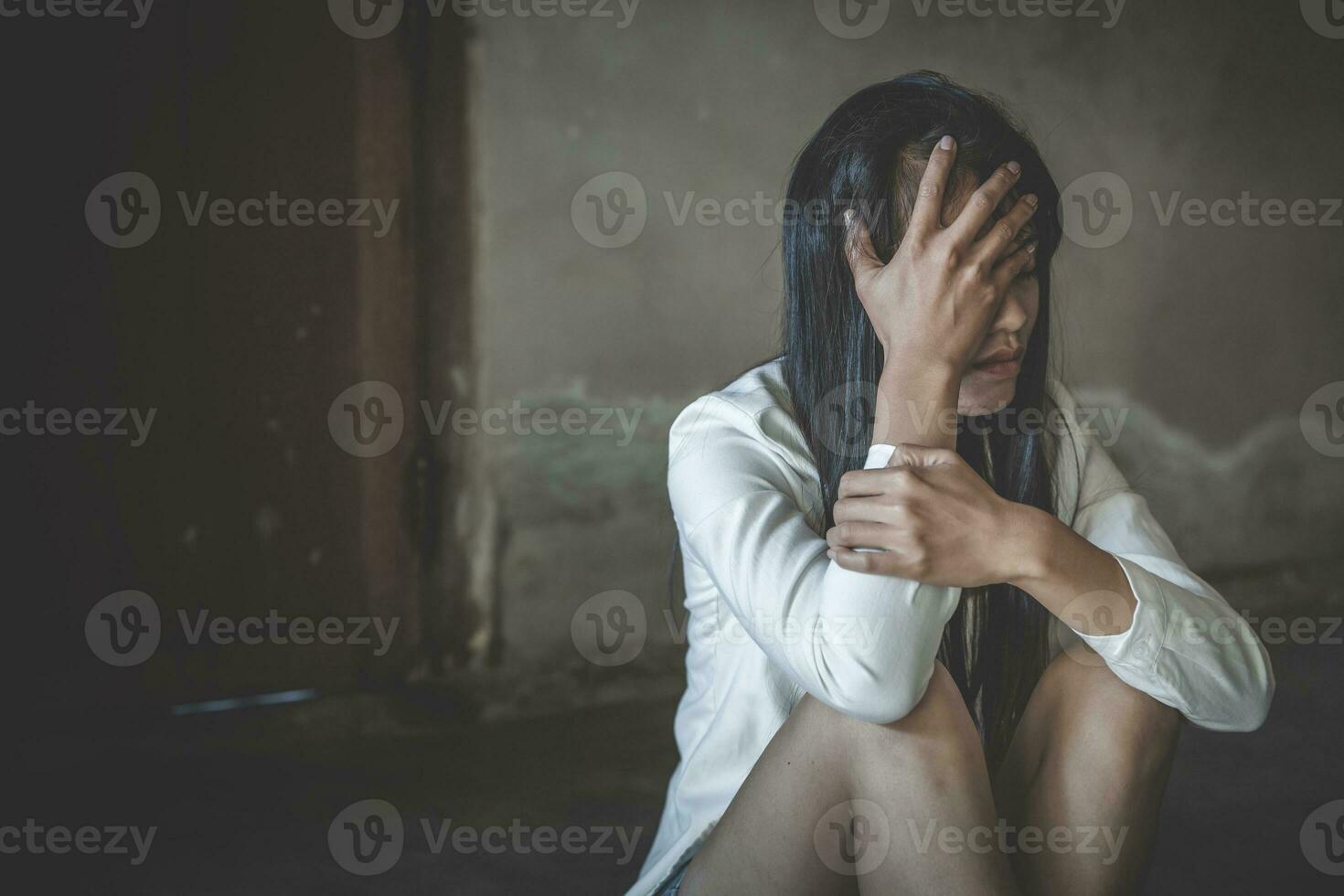 kvinnor som sitter på golvet och gråter av depression, deprimerad kvinna, familjeproblem, stress, kök, övergrepp, våld i hemmet, begreppet depression och självmord. foto