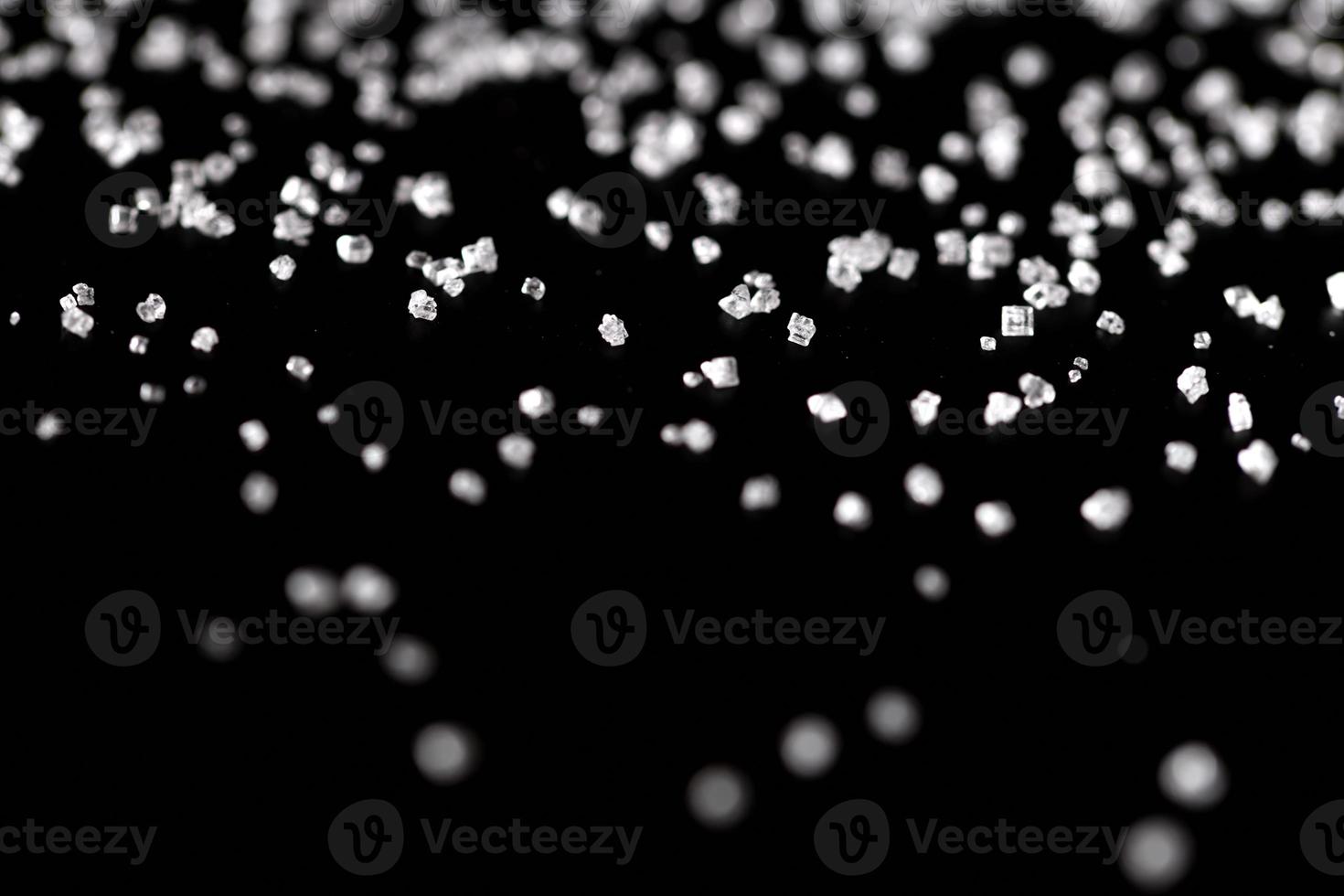 vitt kristallsocker på svart bakgrund foto