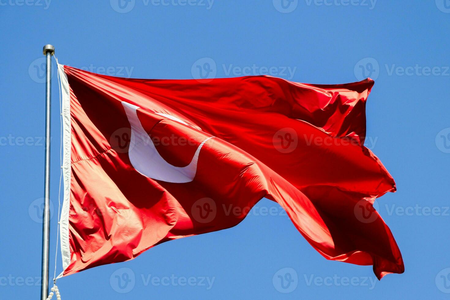 vinka turkiska flagga. himmel bakgrund. flagga med stjärna och halvmåne symbol foto