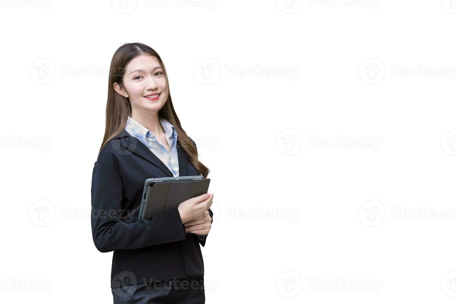 professionell asiatisk ung företag kvinna i svart kostym ler lyckligt medan hon Arbetar och innehar läsplatta isolerat på vit bakgrund. foto