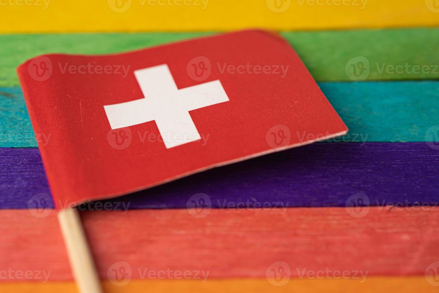 Schweiz flagga på regnbåge bakgrund symbol för HBT gay pride månad social rörelse regnbågsflagga är en symbol för lesbisk, gay, bisexuell, transsexuell, mänskliga rättigheter, tolerans och fred. foto