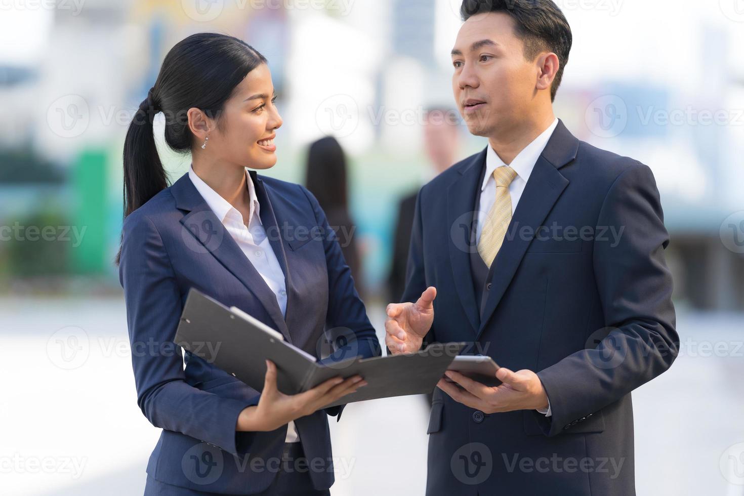 mogen affärsman som använder en digital tablet för att diskutera information med affärskvinnan foto