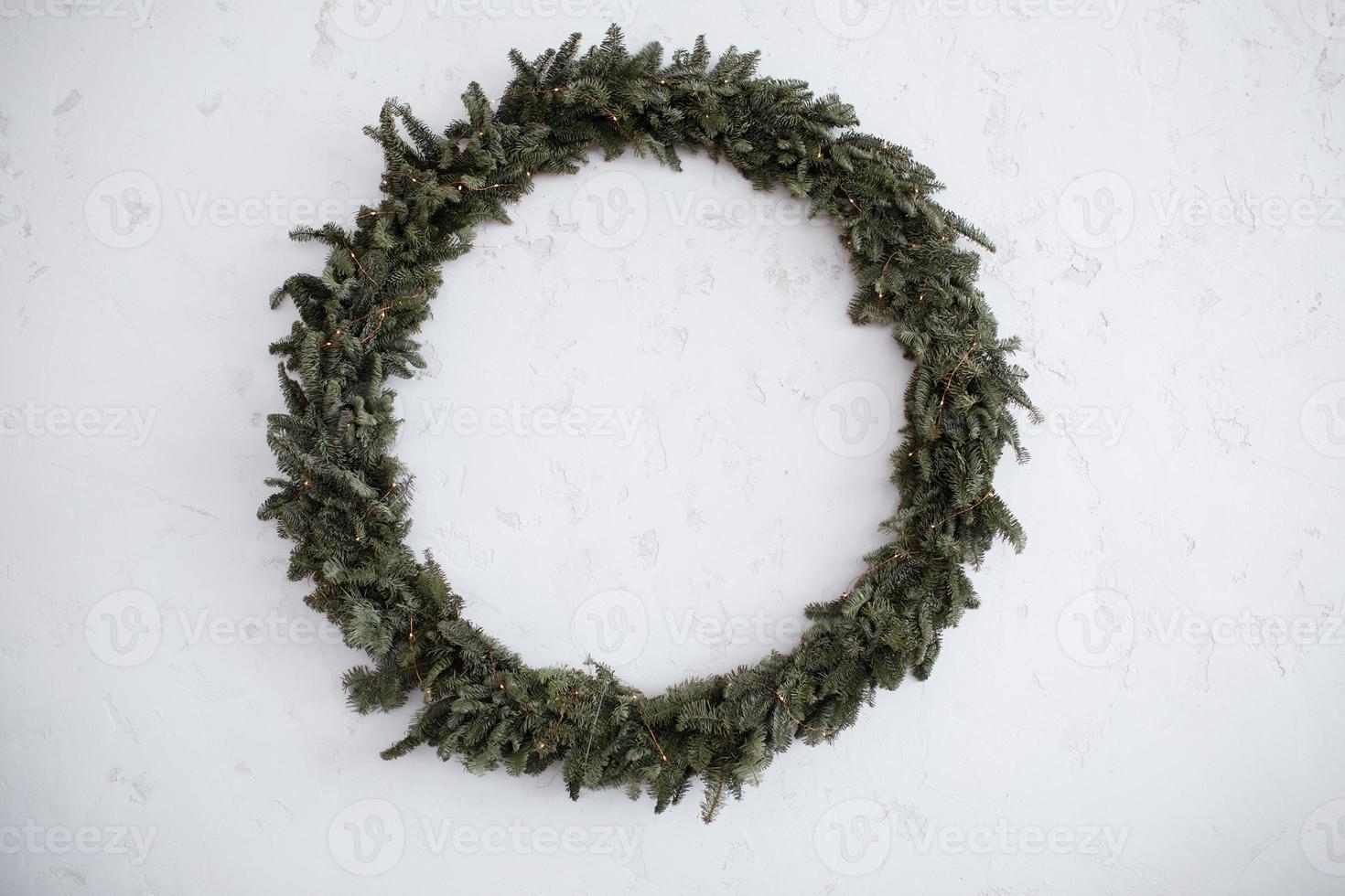 den stora kransen för jul är isolerad på en stenvit bakgrund. rund grön krans. naturlig inredning. högtider. traditioner. foto