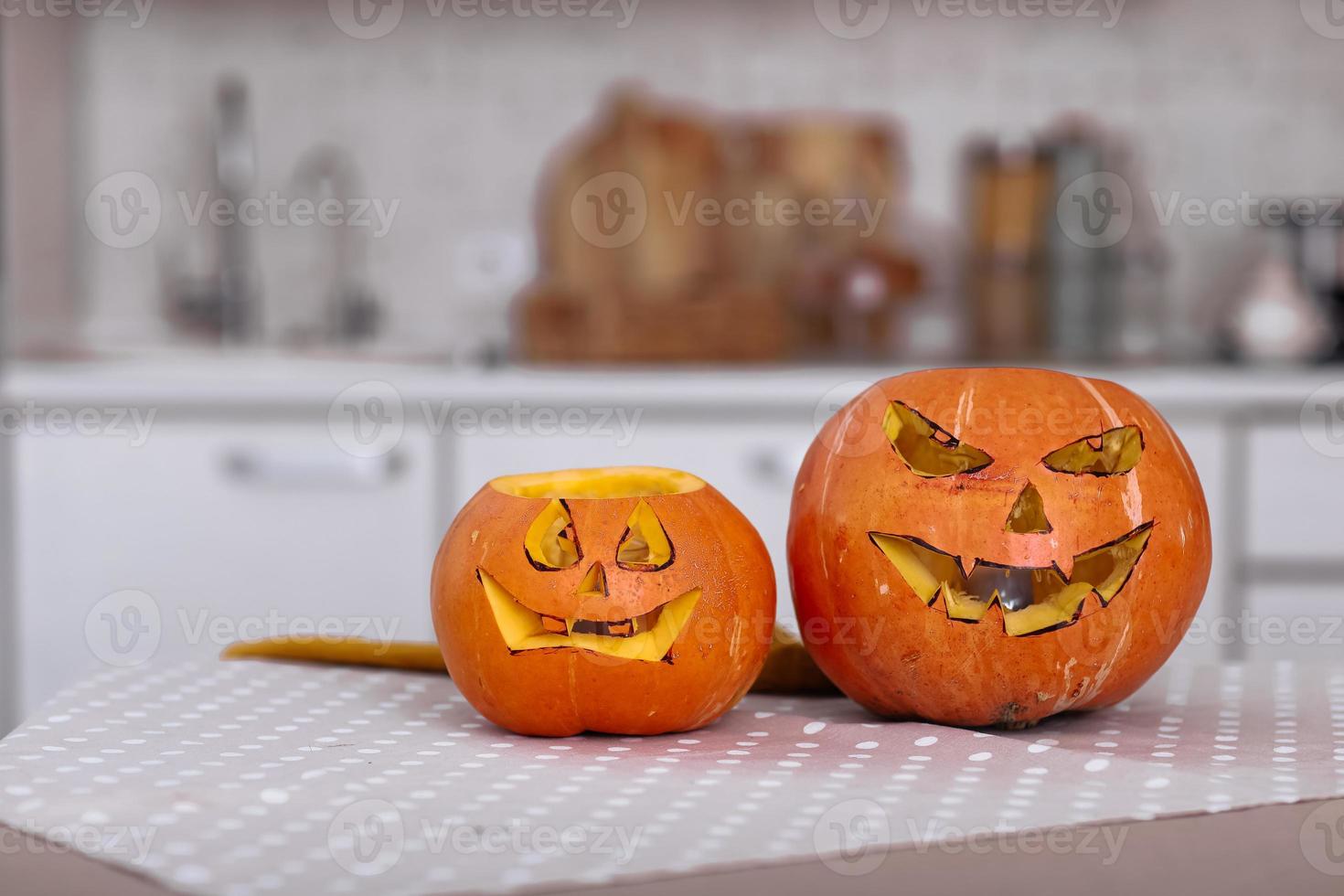 halloween pumpor ler och läskiga ögon för festnatt. närbild av läskiga halloween pumpor med ögon på bordet hemma. selektivt fokus foto