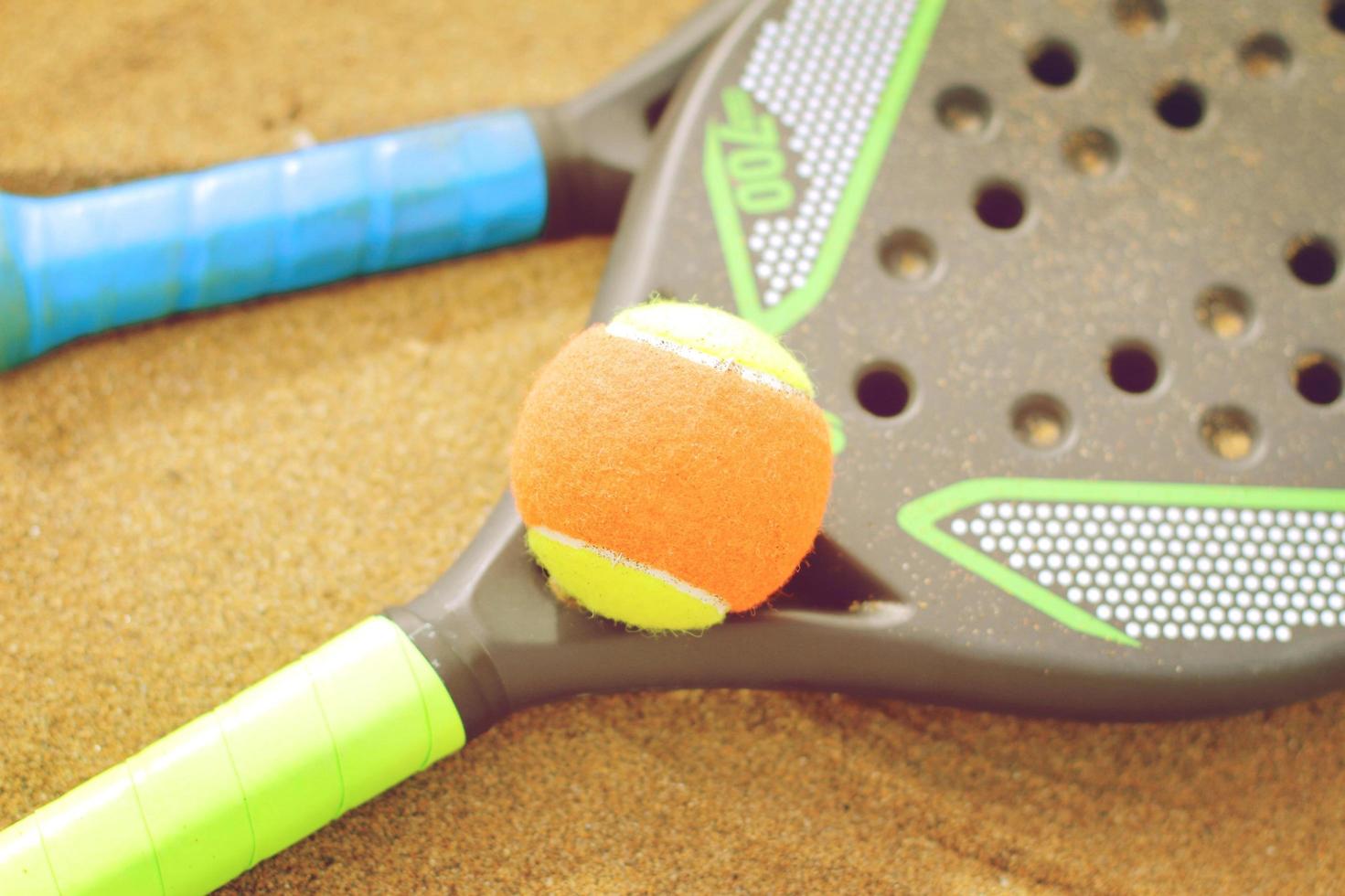 strandtennisracketar i sanden foto