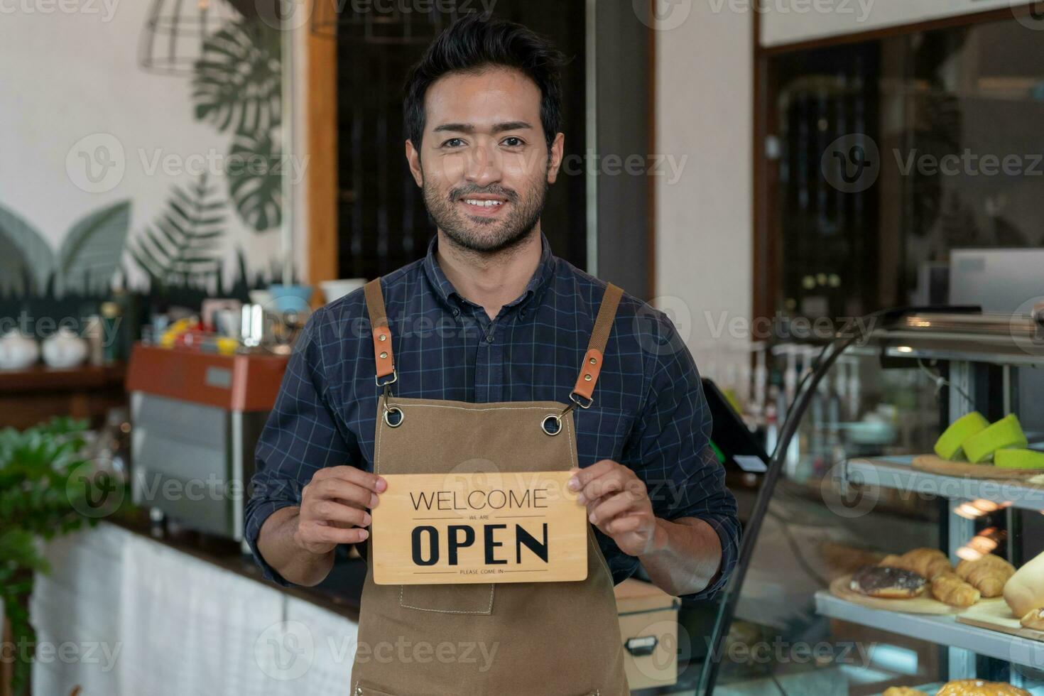 företag man ägare visa tecken öppen på de först dag av företag. garantier säkerhet, renlighet, öppen de kaffe affär. öppen för ny vanligt. små företag, Välkommen, restaurang, Hem tillverkad foto