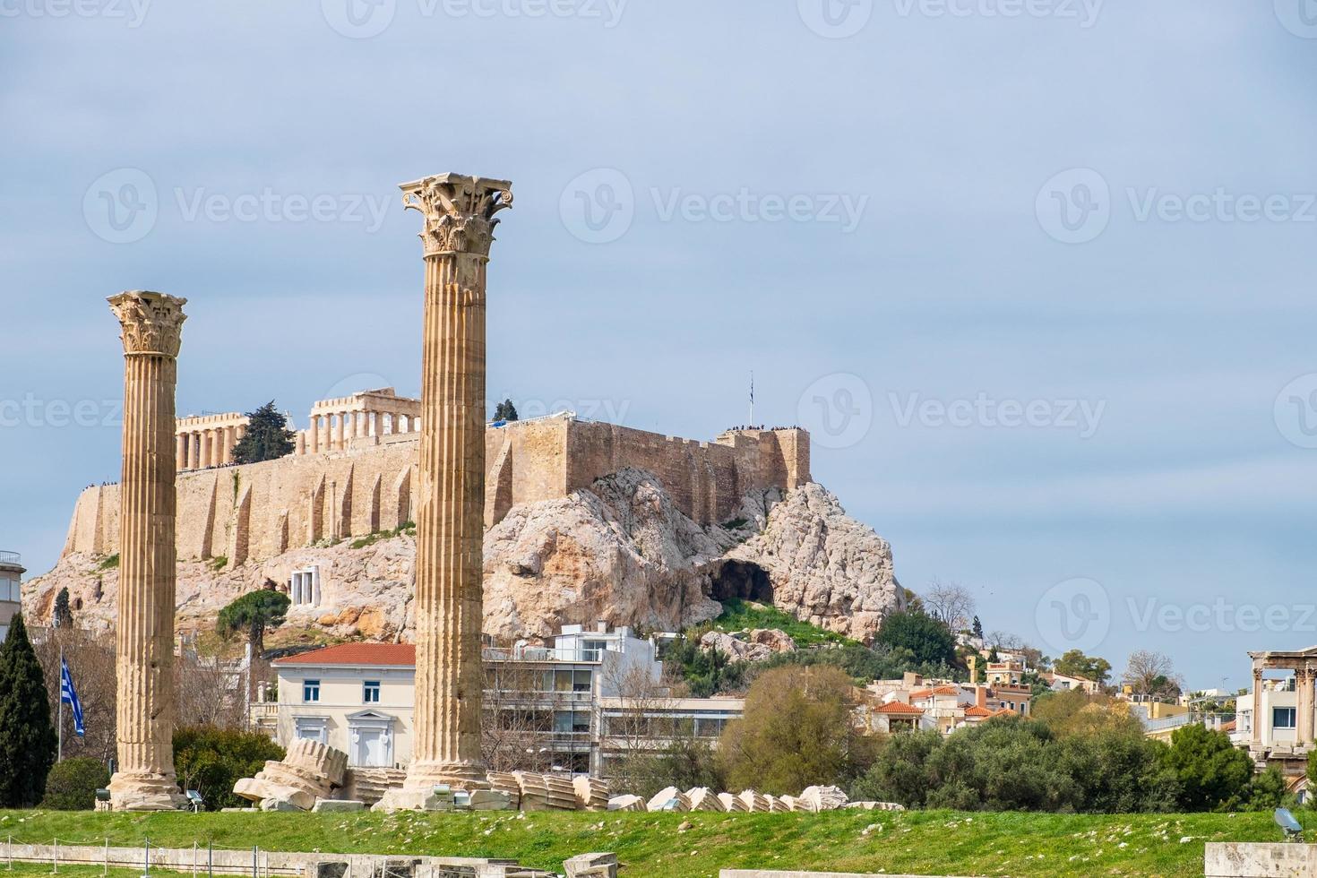 ruinerna av det forntida tempelet för olympiska zeus i Aten med akropoliskullen i bakgrunden foto