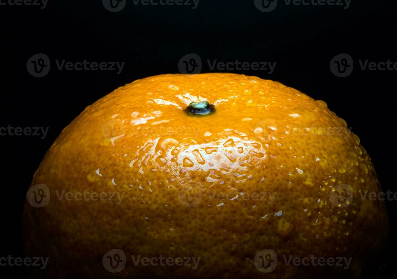 vattendroppe på blank yta av friskhet orange på svart bakgrund foto