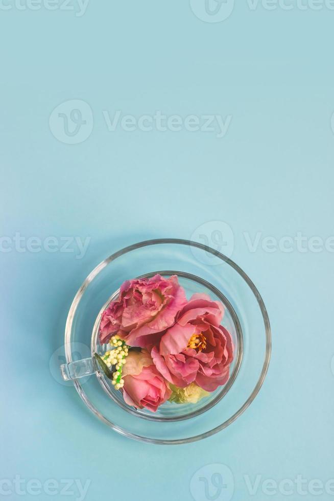 ovanifrån av en genomskinlig glaskopp full av blommor våren bakgrund med kopia utrymme foto