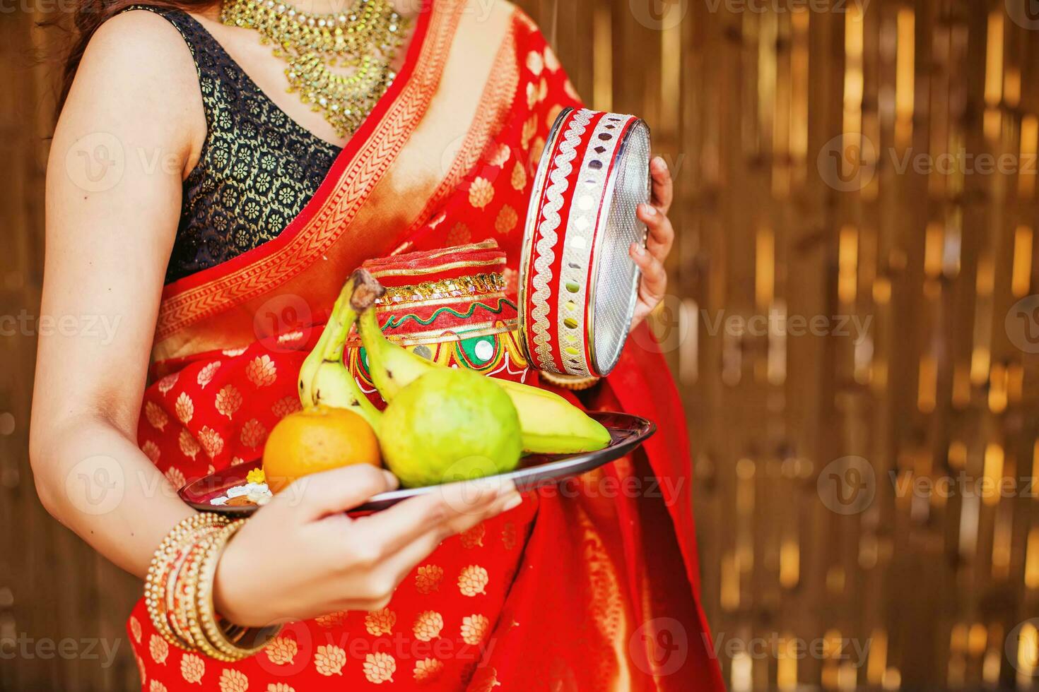 en kvinna i en sari innehav en tallrik med frukt foto