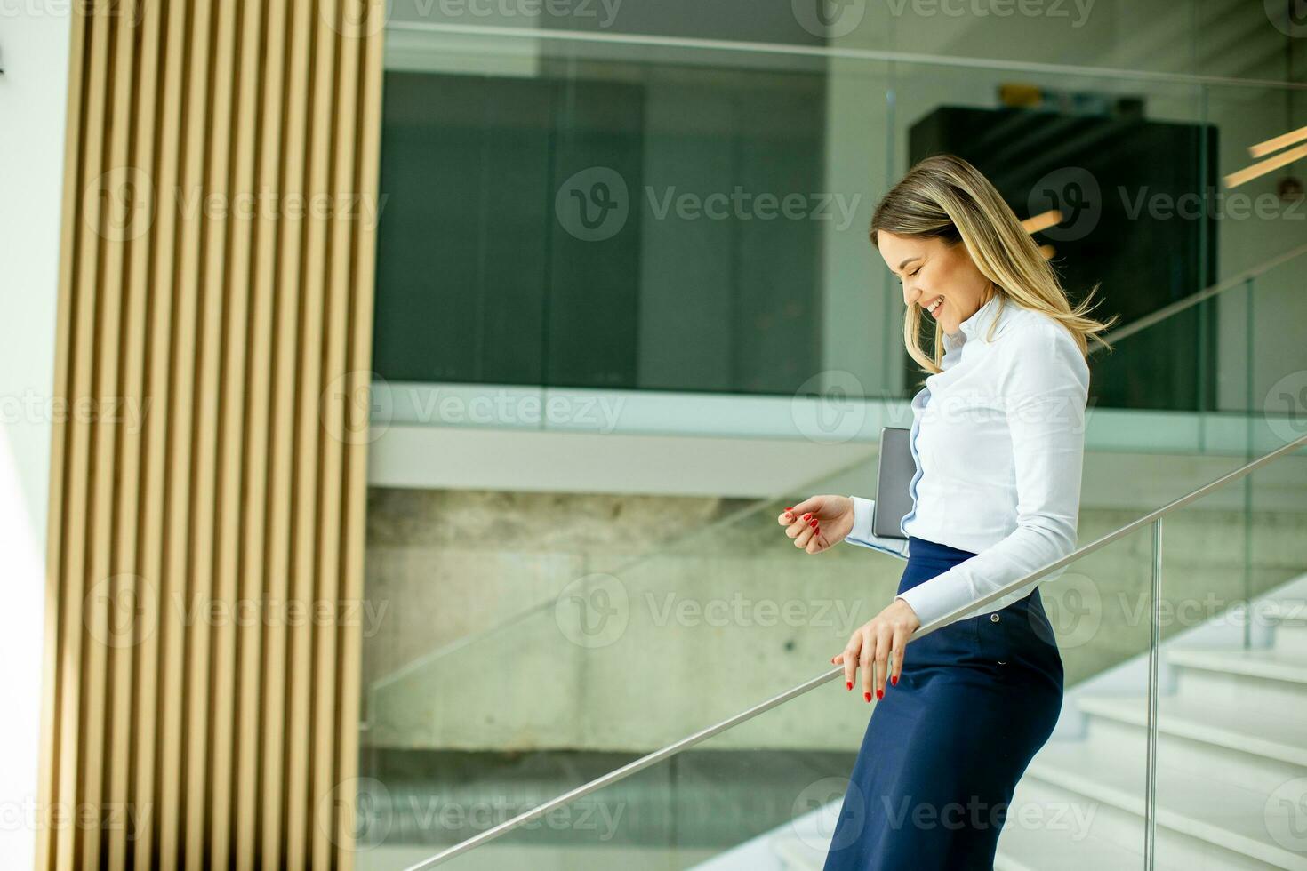 yung företag kvinna gående på trappa i de kontor hall foto