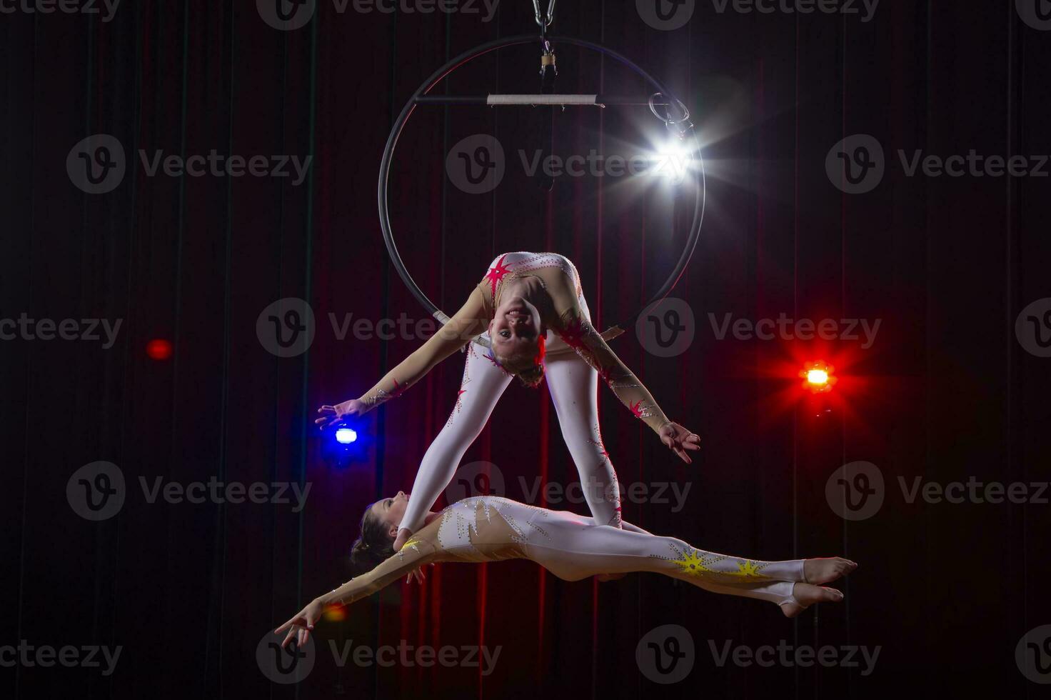 cirkus akrobater gymnaster prestera på en skede mörk bakgrund. foto