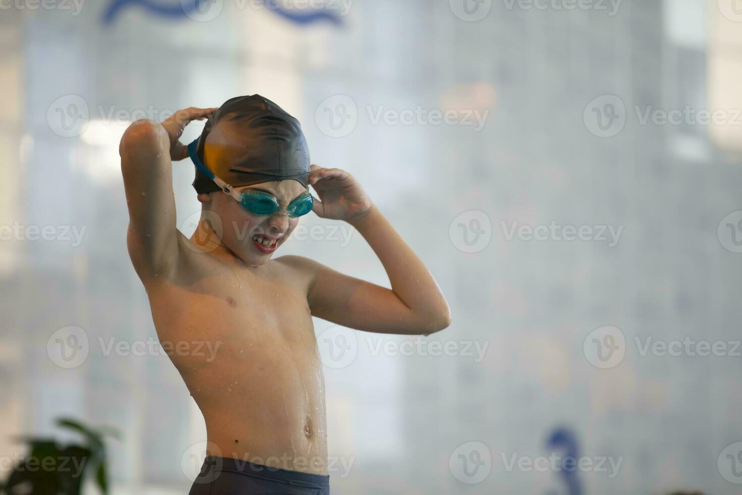pojke i en simning keps och simning glasögon i de slå samman. de barn är engagerad i de simning sektion. foto