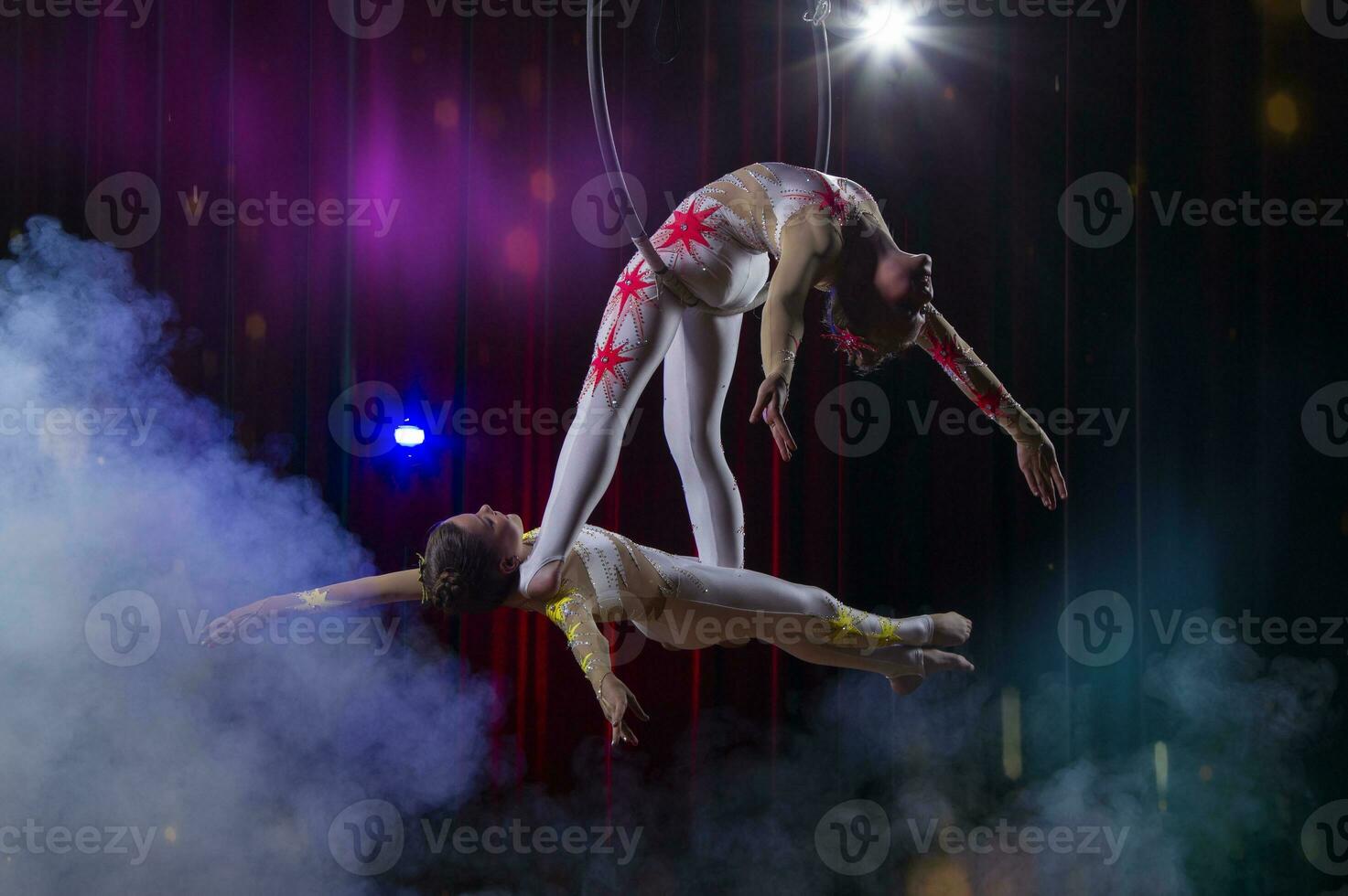 cirkus akrobater gymnaster prestera på en skede mörk bakgrund. foto