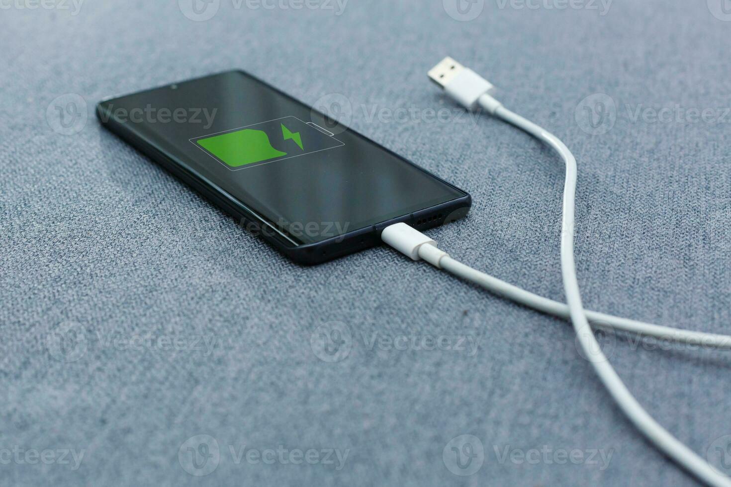 mobil smart telefoner laddning på grå bakgrund foto