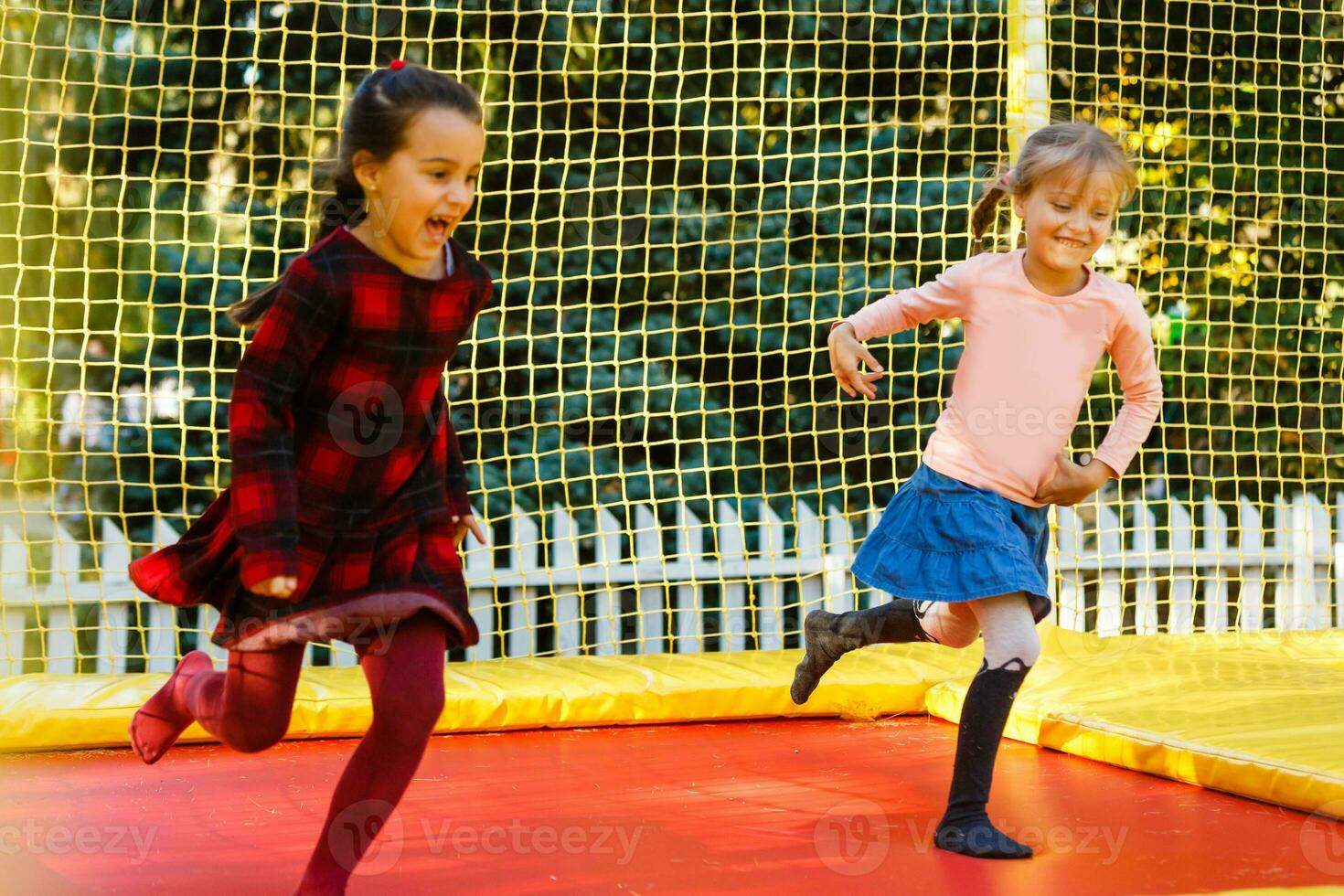 Lycklig skola flicka Hoppar på trampolin i de höst parkera foto