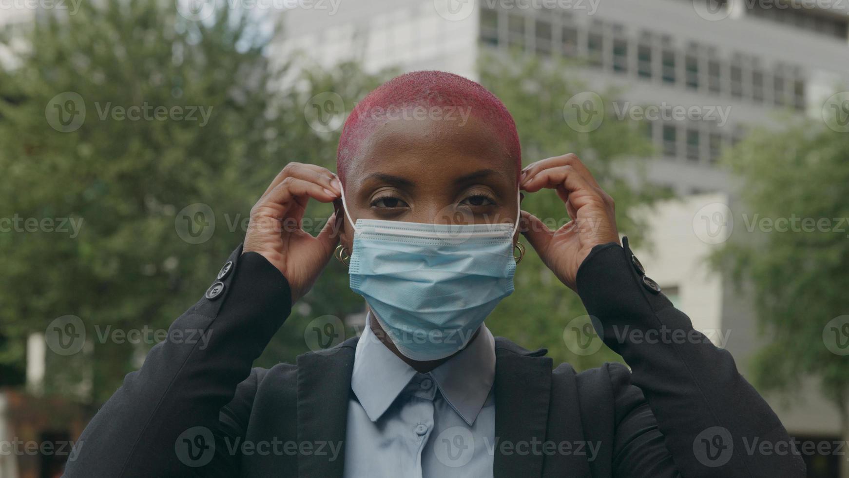 porträtt av ung kvinna att sätta på skyddande ansiktsmask foto