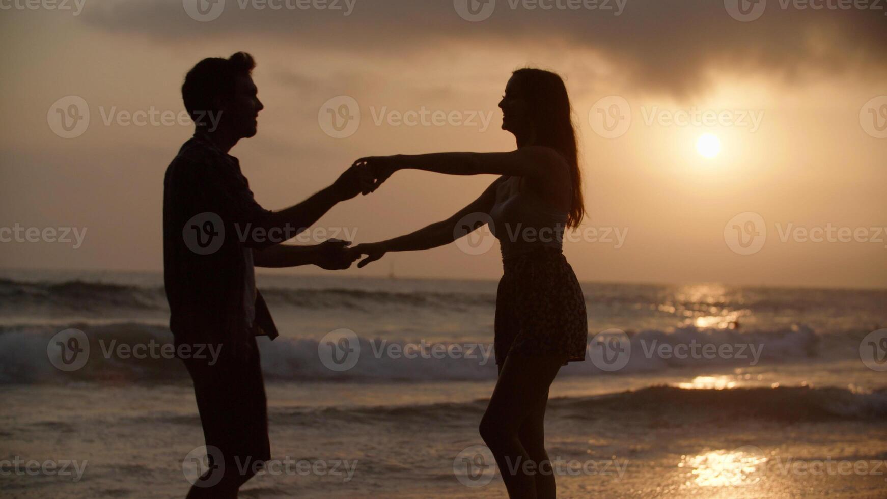 porträtt av ungt par som dansar på stranden foto