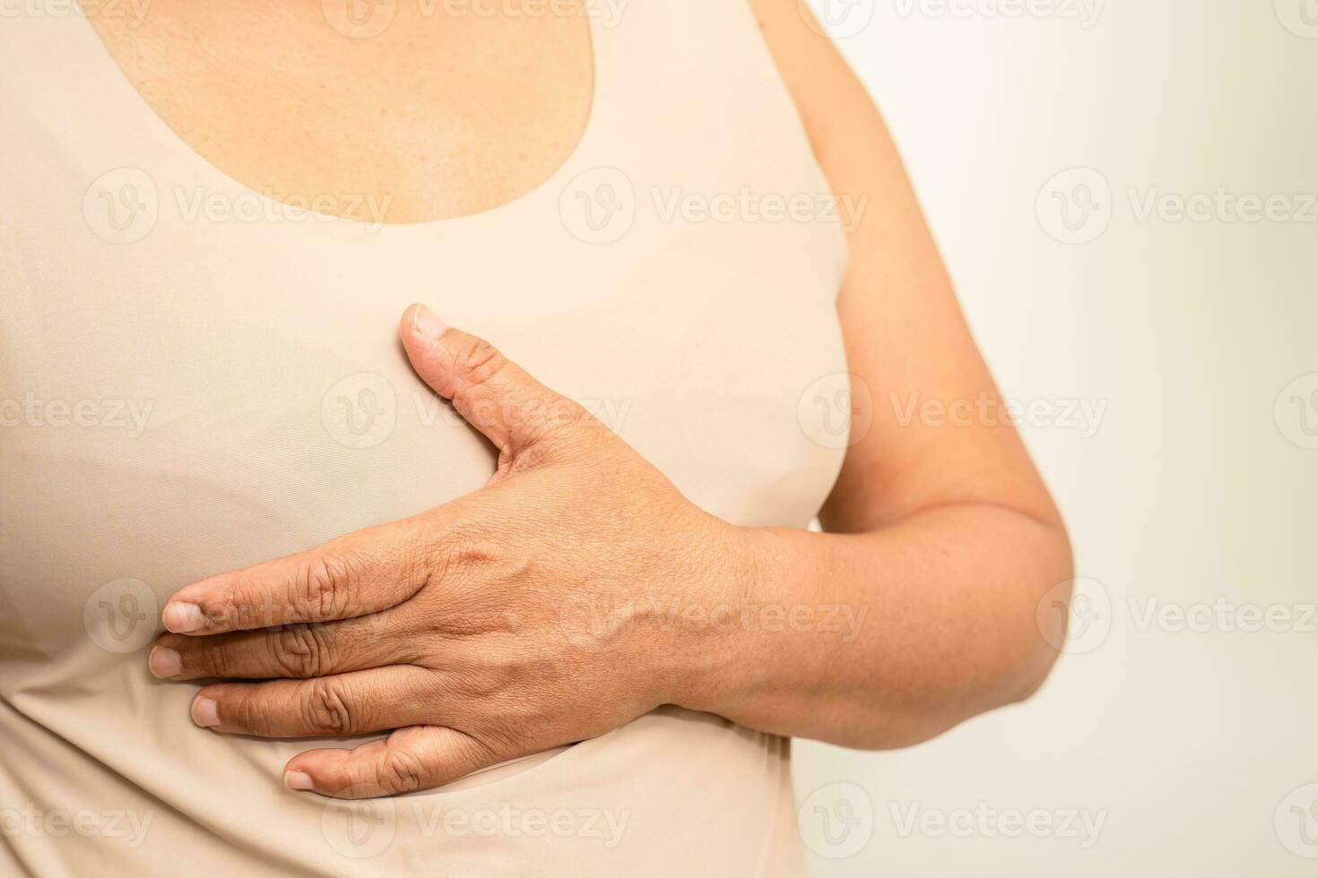 asiatisk kvinna patient kontroll och oroa henne bröst, bröst själv examen eller vara s, symbol av värld bröst cancer dag. foto