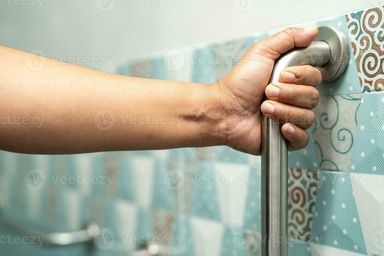asiatisk äldre kvinna använda sig av badrum hantera säkerhet i toalett, friska stark medicinsk begrepp. foto