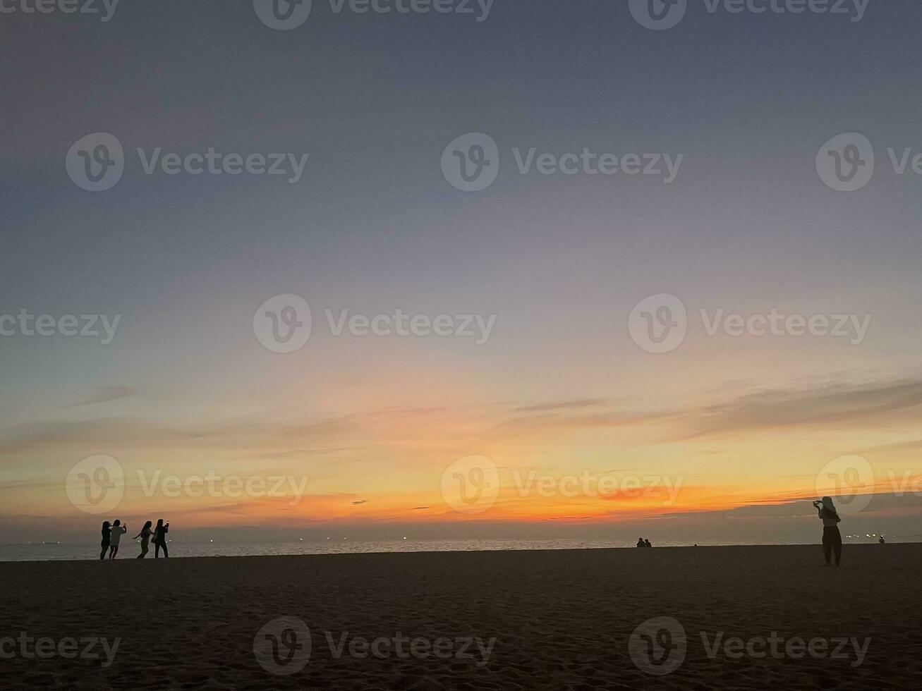 människor på de strand i kväll foto