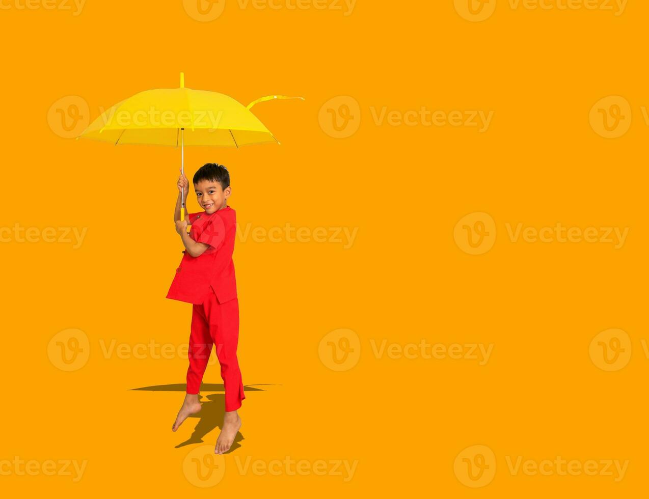 pojke mode en kinesisk stil skjorta innehav en gul paraply poser för en Foto skjuta.