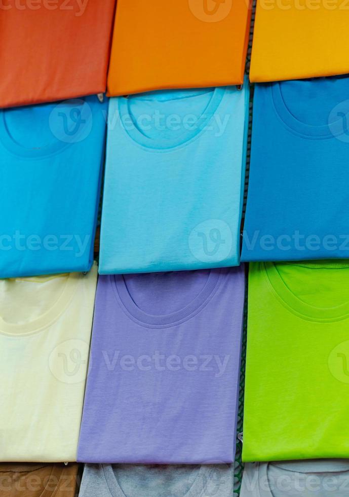 närbild av färgglada t-shirts på galgar foto