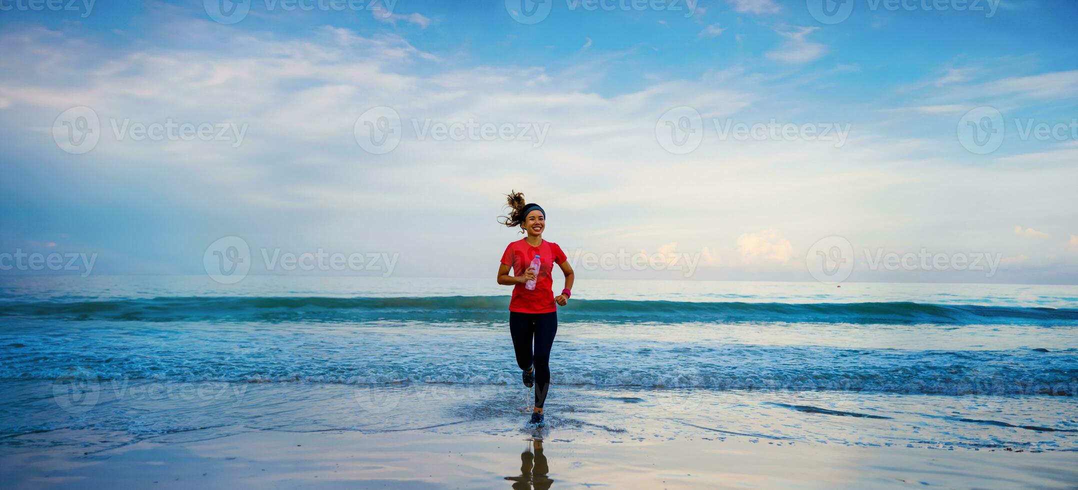 flicka kör träning jogging på stranden på morgonen. slappna av och nöjd med att springa på havet. i sommar foto