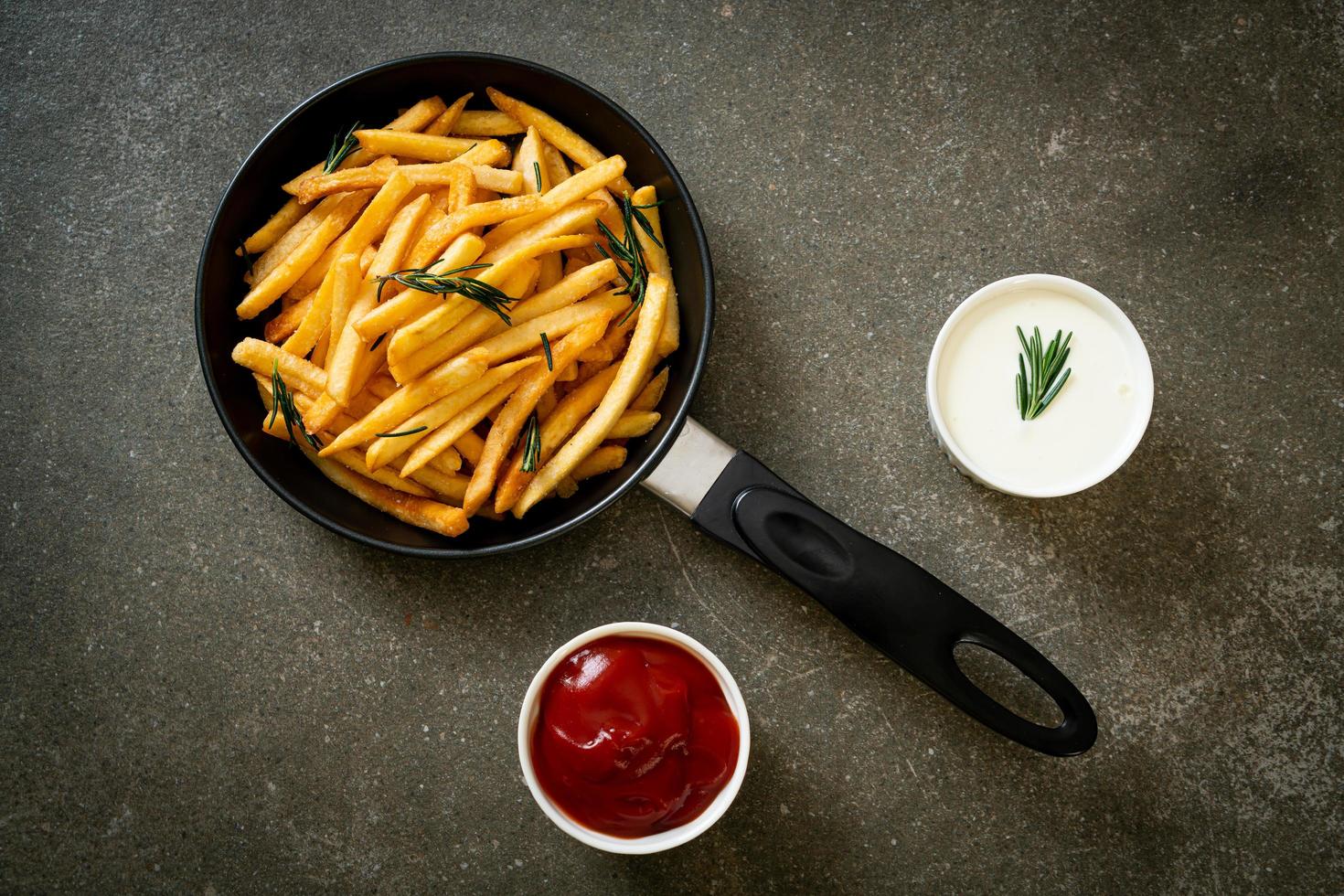 pommes frites med gräddfil och ketchup foto