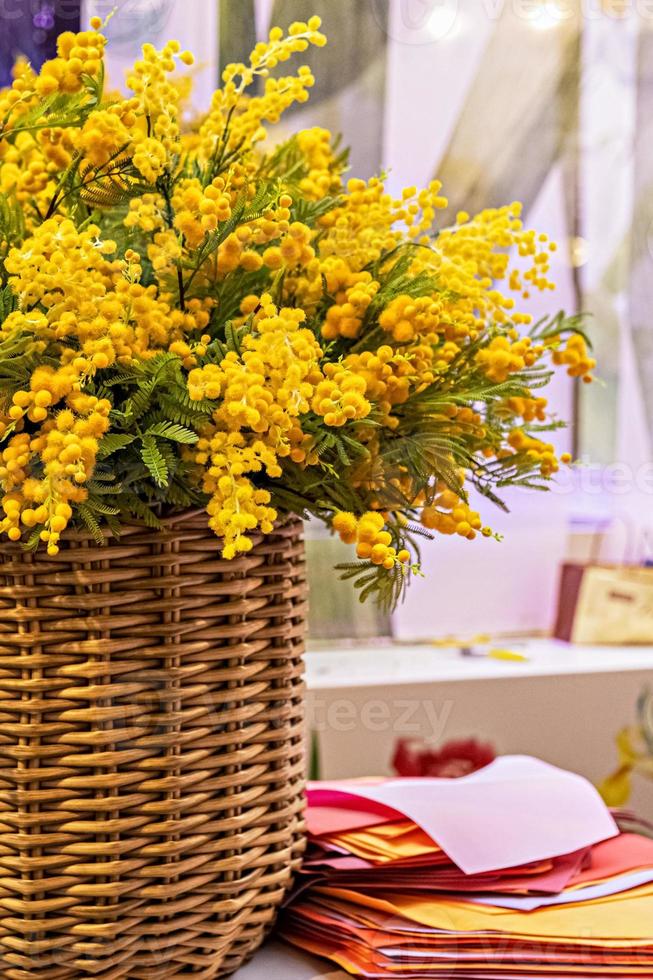 en bukett blommande gula grenar av silverakacia i en hög korg. våren blommar foto